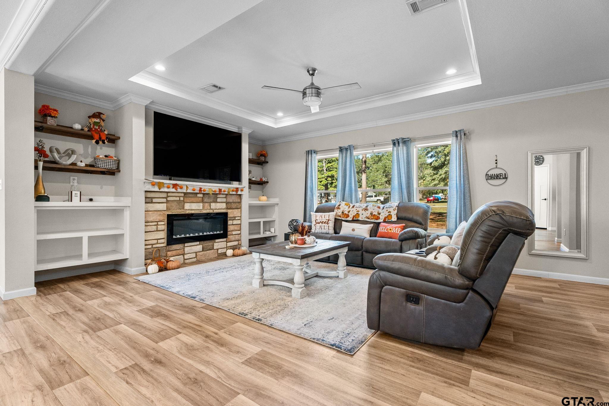 a living room with furniture a flat screen tv and a fireplace