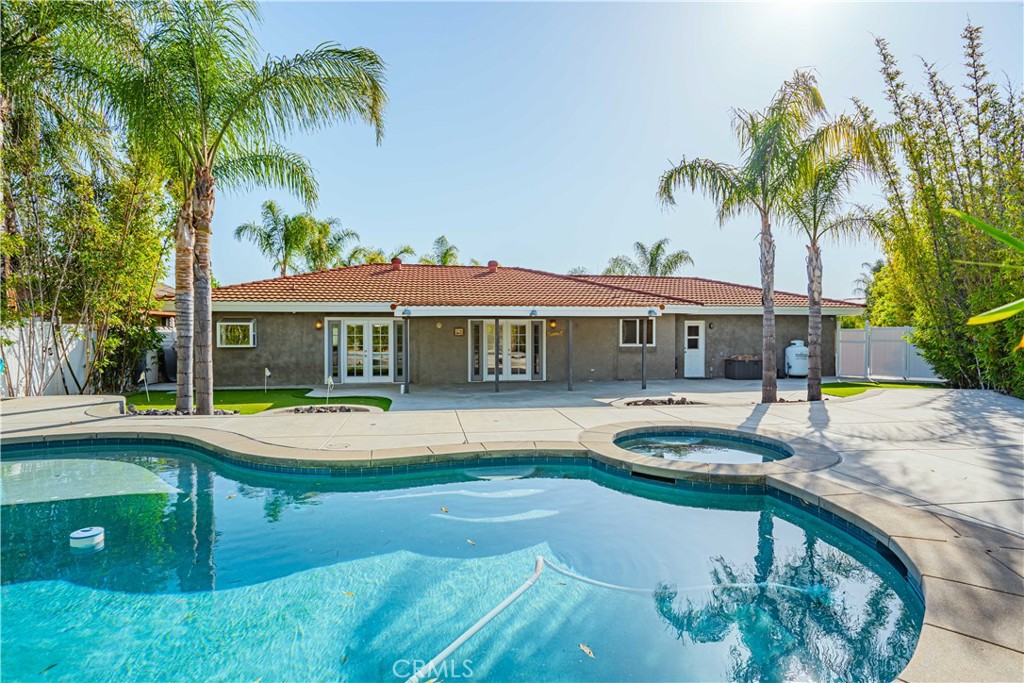 a front view of a house with swimming pool having outdoor seating