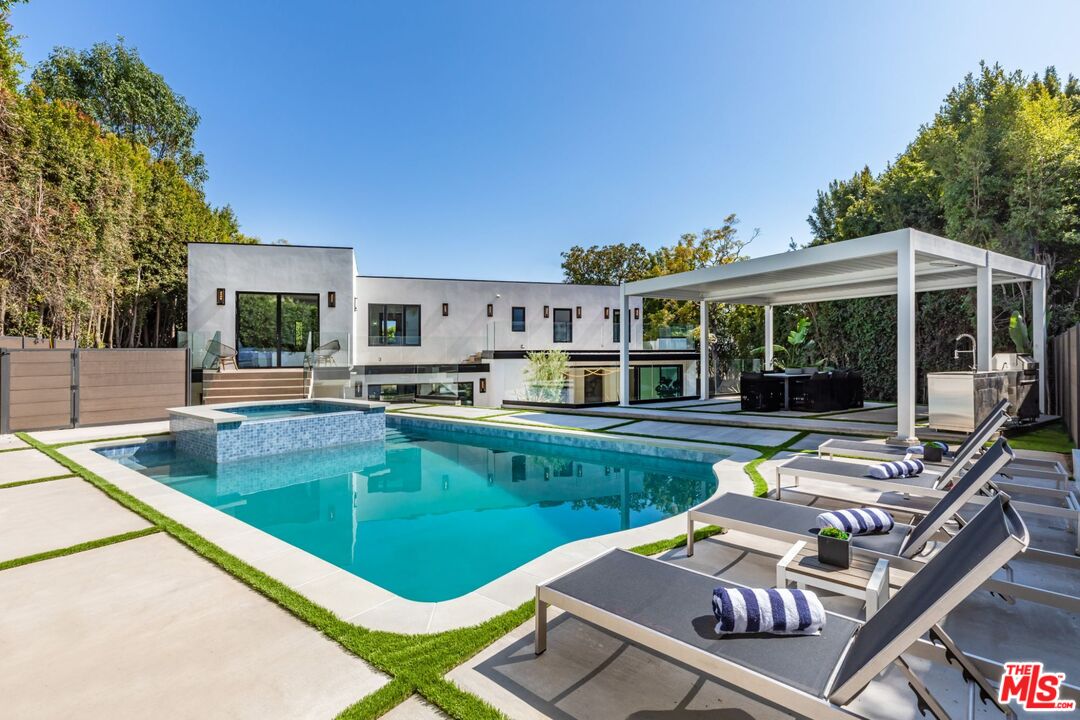 a view of a house with pool and chairs