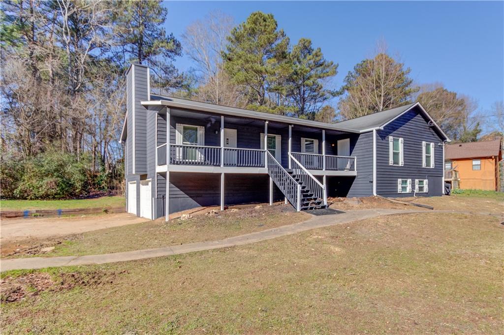 a view of a house with a backyard and porch