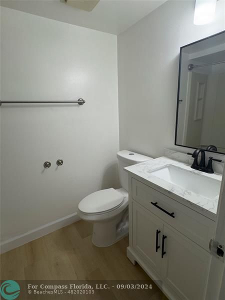 a bathroom with a granite countertop toilet and a sink