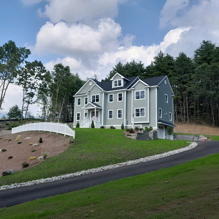 a view of house with garden and tall trees