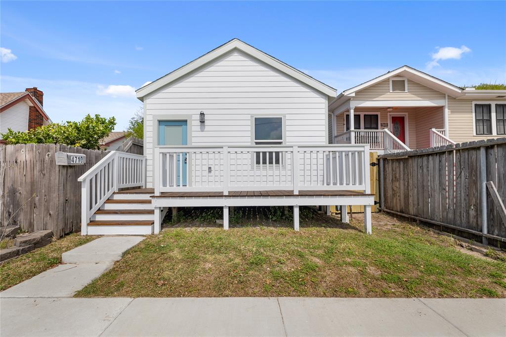 a view of a house with a wooden deck and furniture