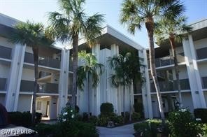 a front view of multi story residential apartment building with yard and green space