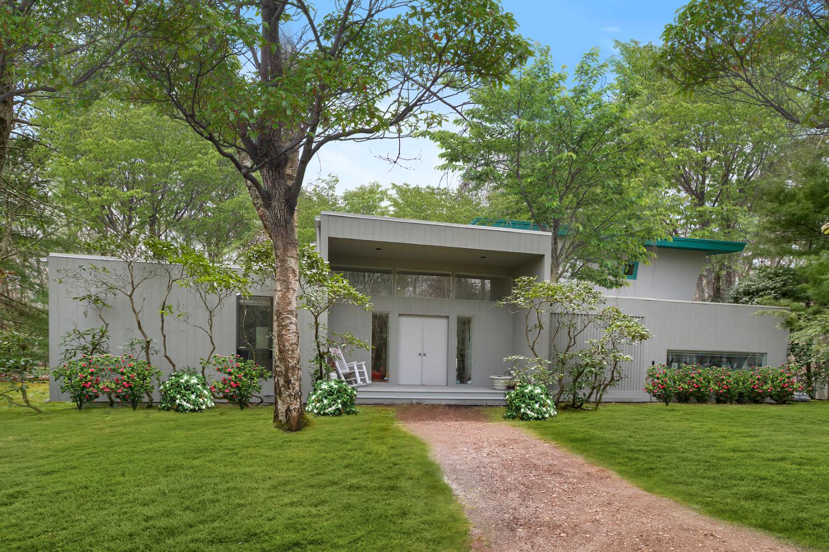 a view of a white house with a big yard and large tree