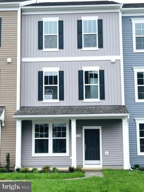 a view of brick building with a window and a yard