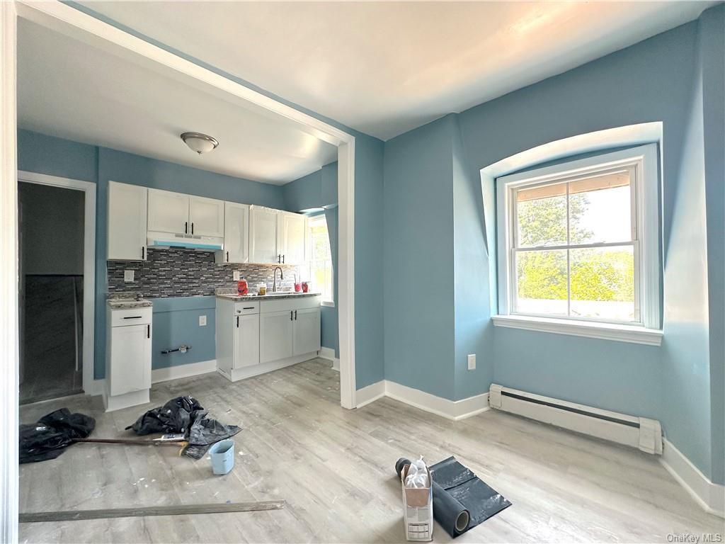 a kitchen with a refrigerator and white cabinets