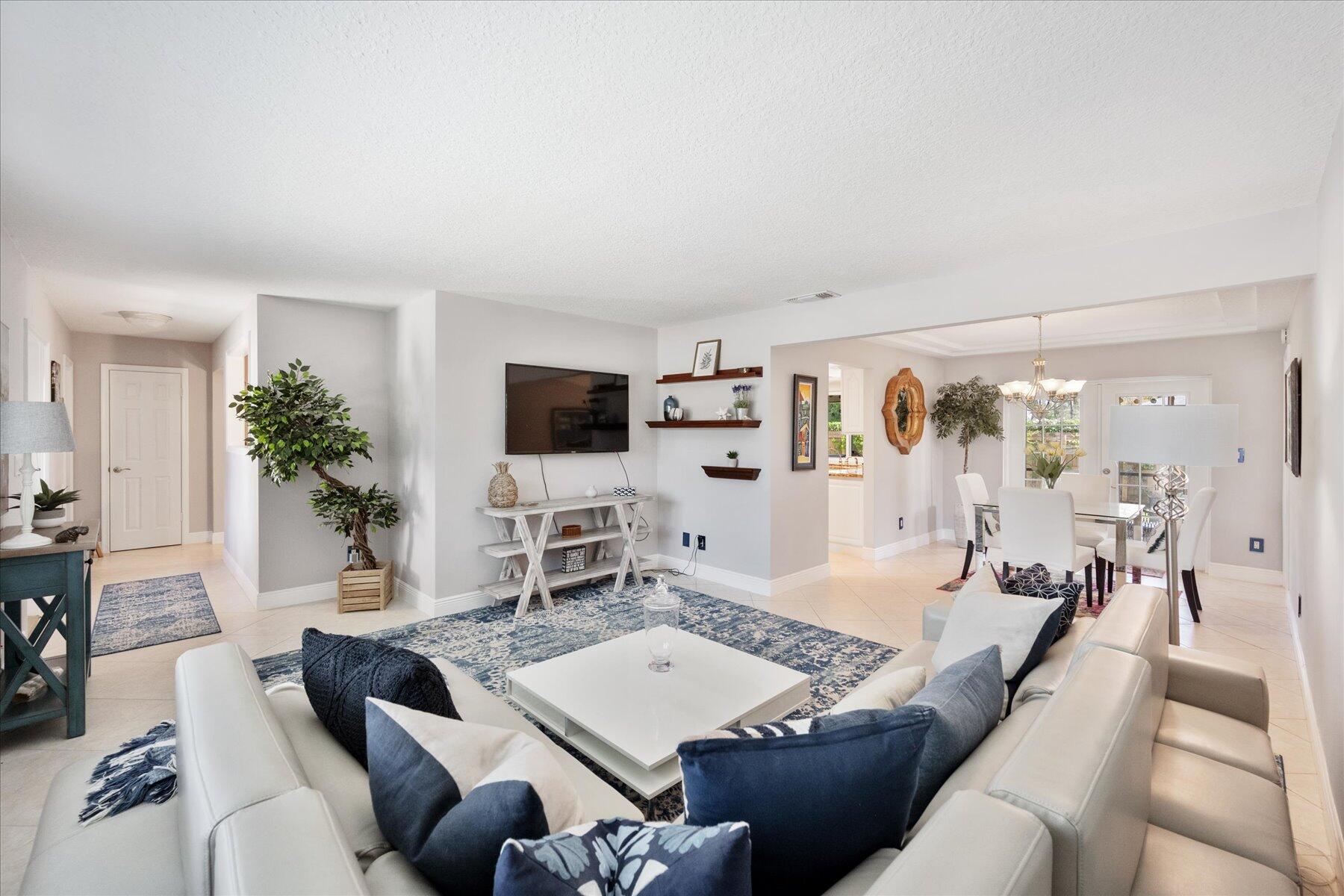 a living room with furniture a flat screen tv and a large window