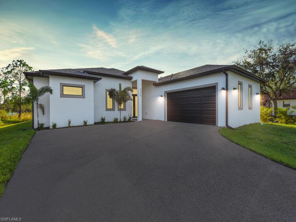 Prairie-style home featuring a garage and a front lawn