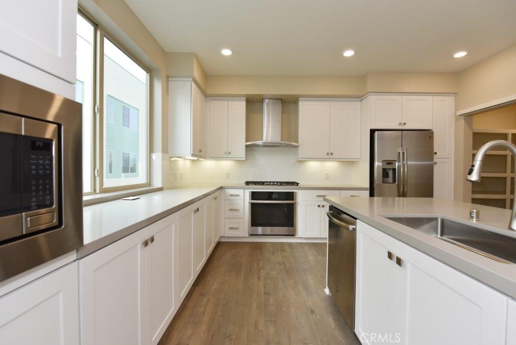 a large kitchen with stainless steel appliances granite countertop a stove a sink and a refrigerator