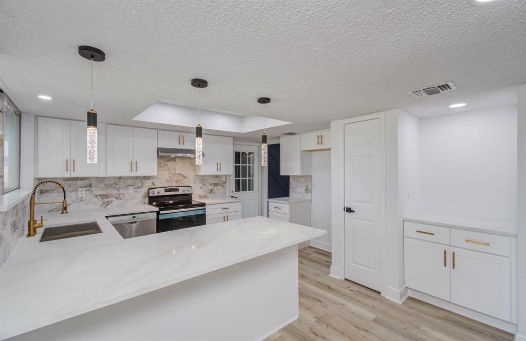 a large white kitchen with stainless steel appliances