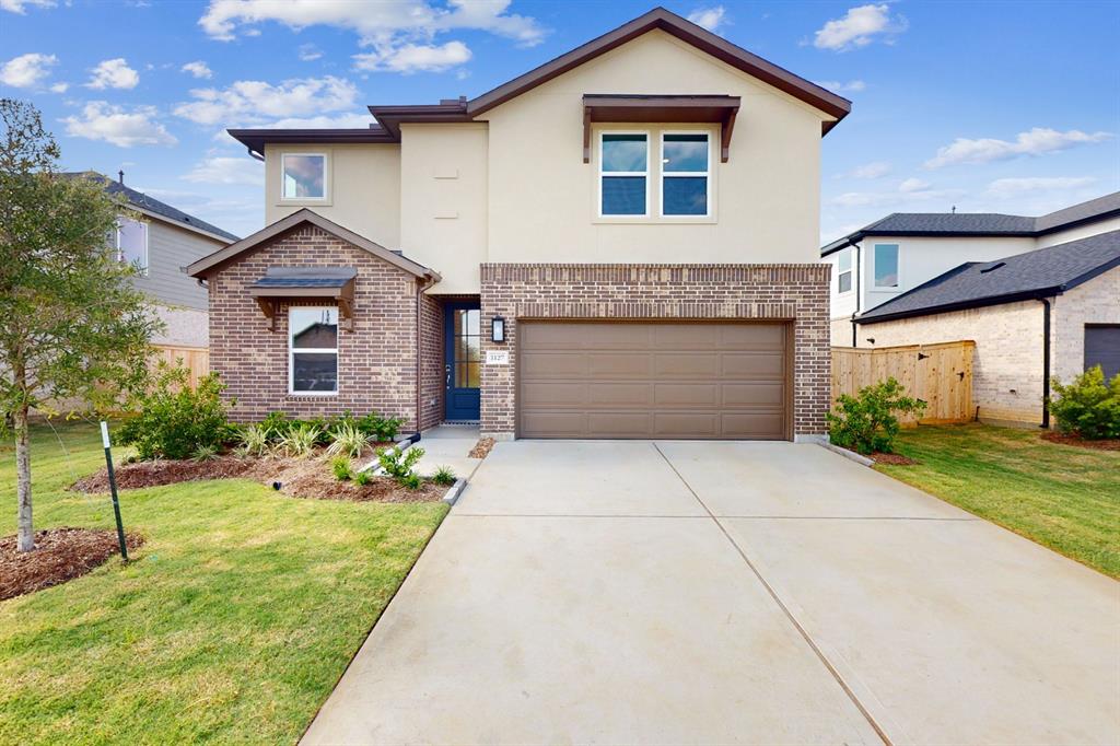 a front view of a house with a yard and garage