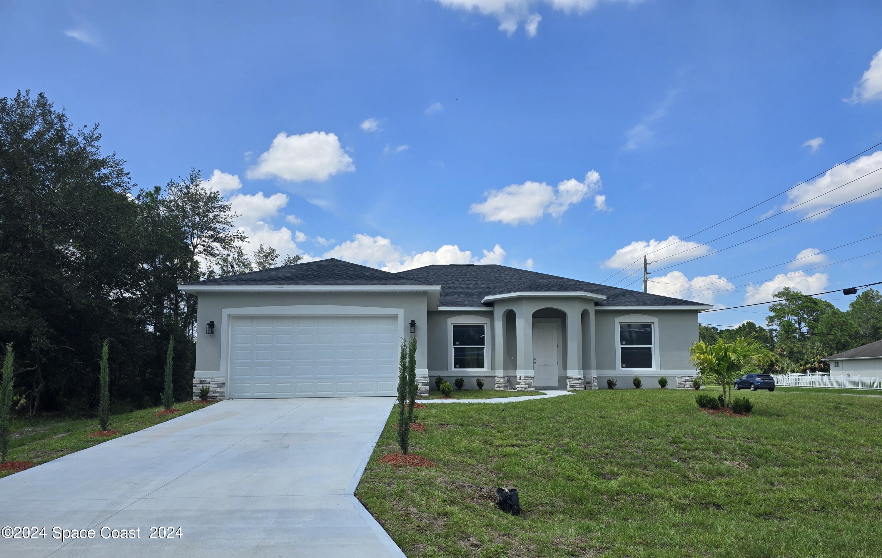 a front view of a house with a yard and garage