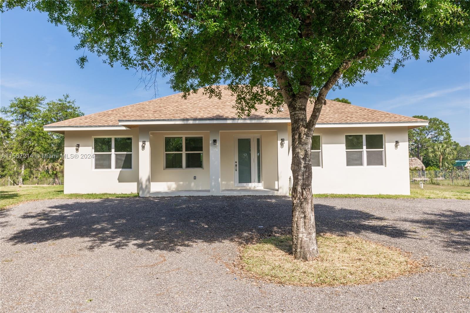 a front view of a house with yard tree and wooden fence