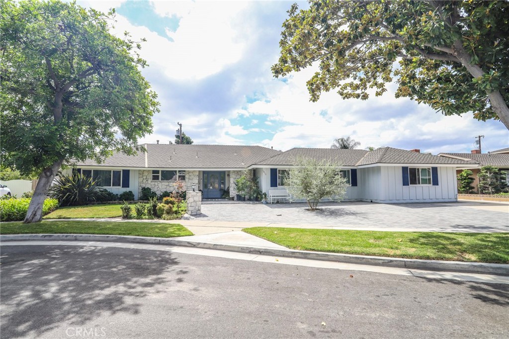 a view of a house with a big yard and large trees