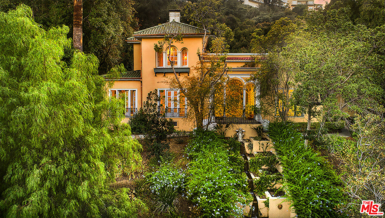 a yellow building with trees in the background