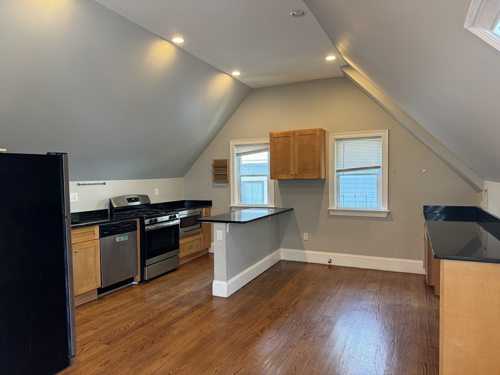 a kitchen with granite countertop a stove and a refrigerator