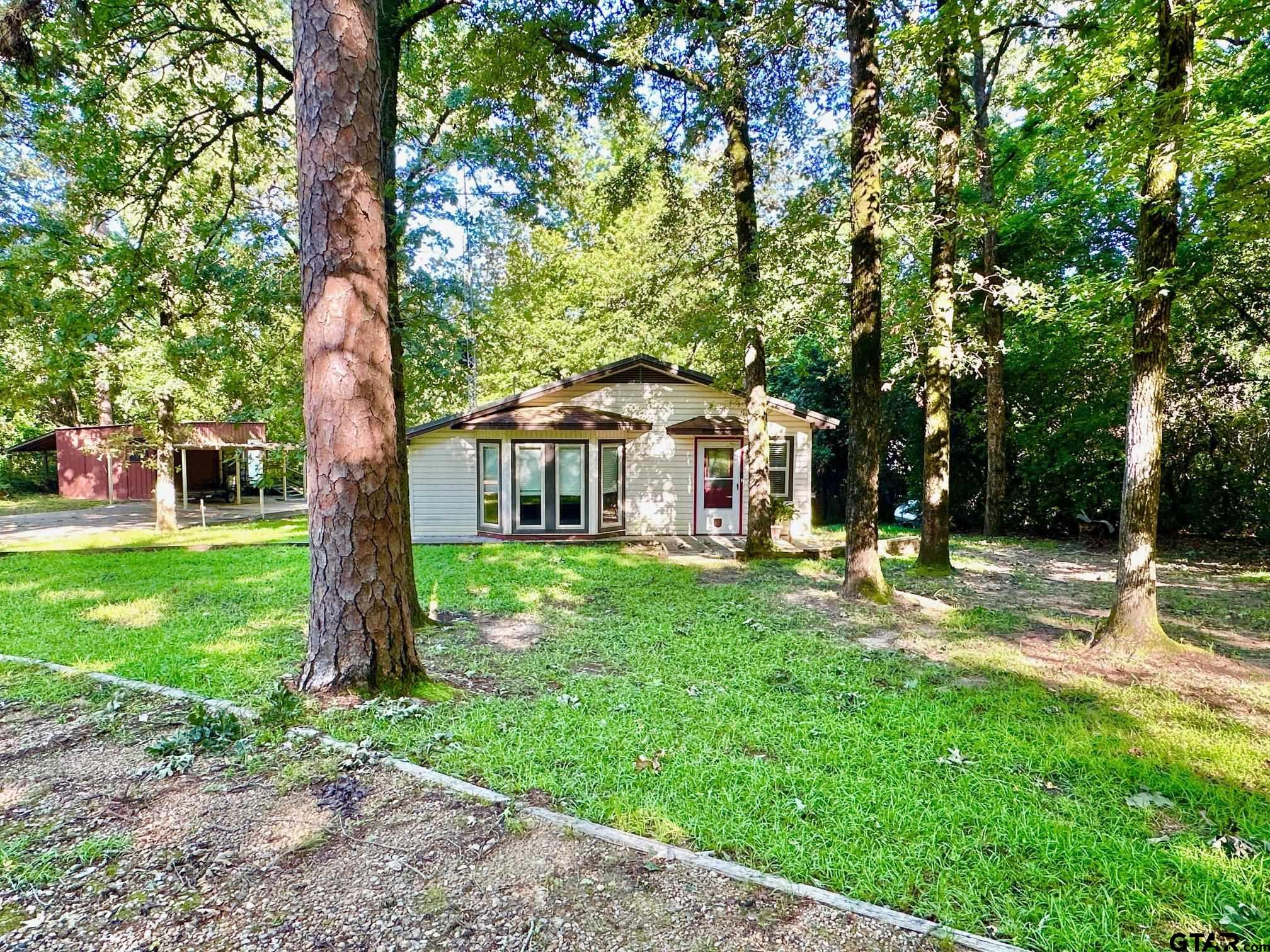 a view of a house with backyard and a tree