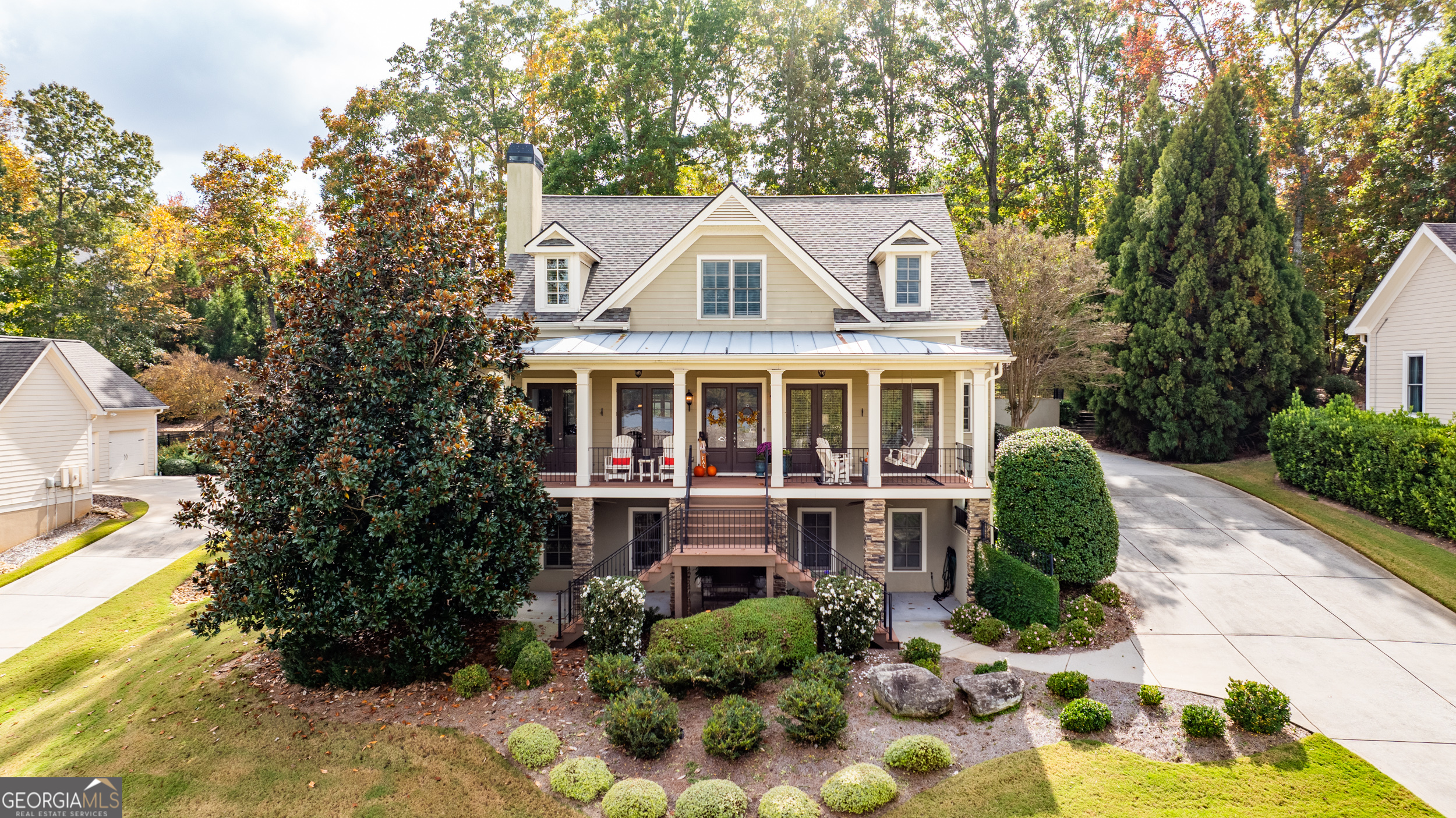 a view of a white house with a yard and potted plants