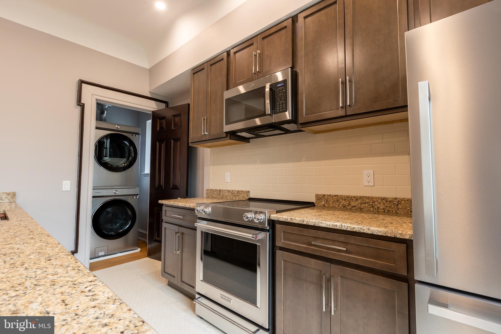 a kitchen with stainless steel appliances granite countertop a stove a microwave and cabinets