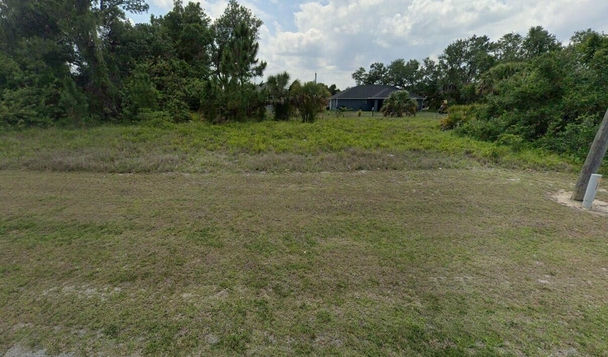 a view of a field with trees in the background