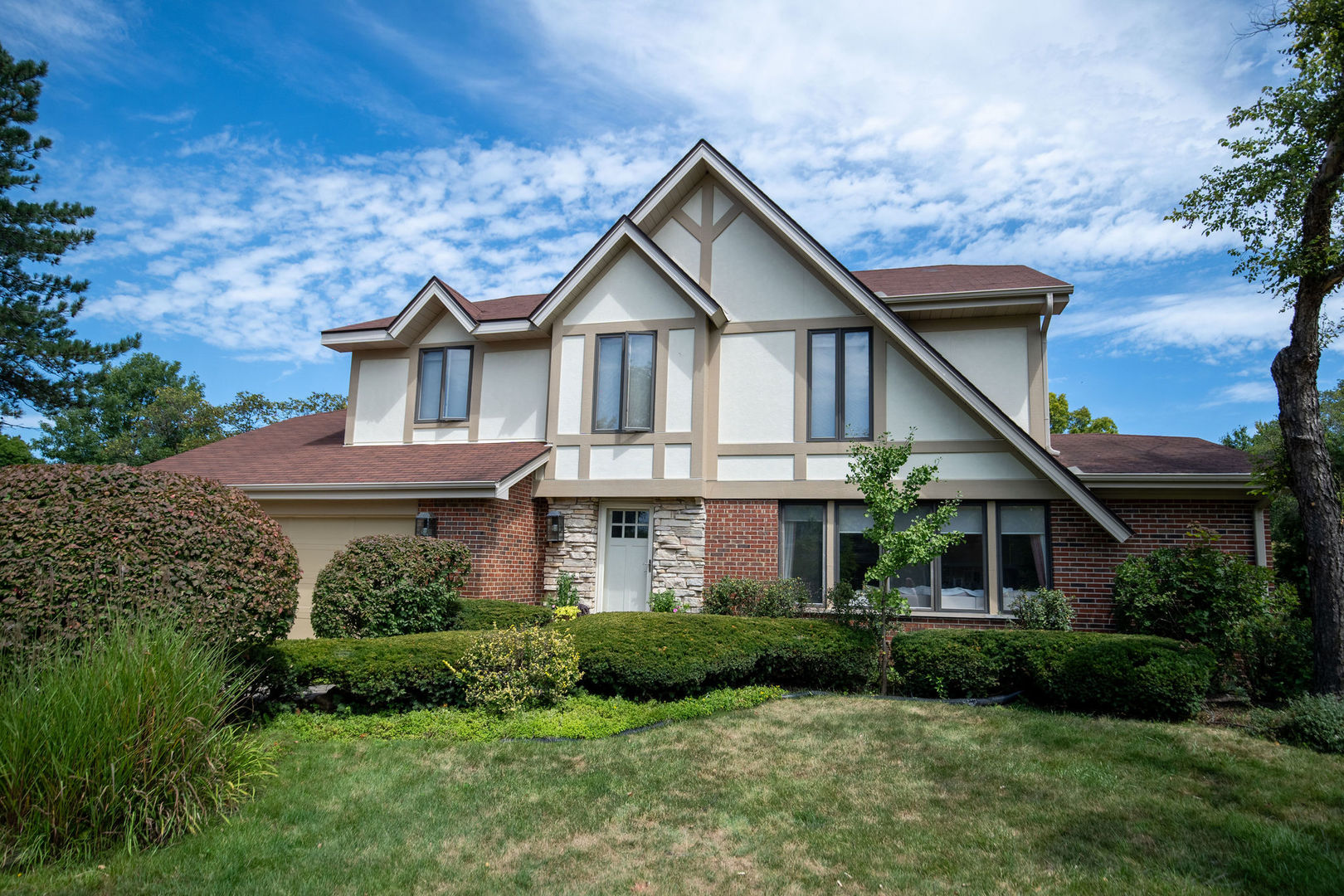 a front view of a house with a yard and green space