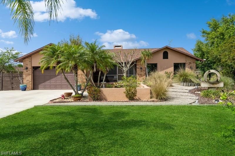 a view of a house with backyard and a tree