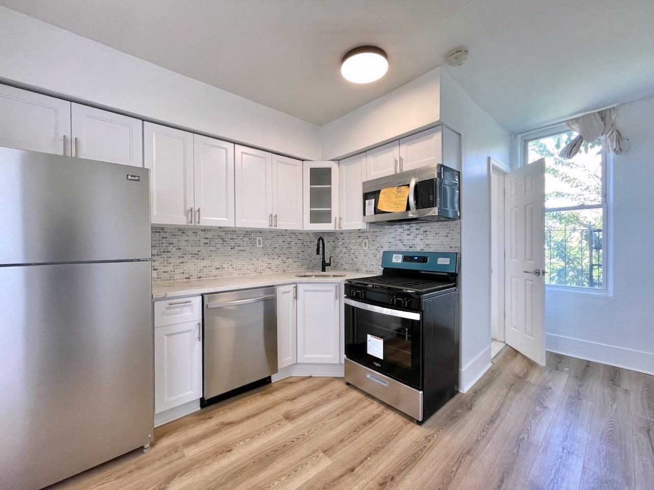 a kitchen with granite countertop a refrigerator stove and sink