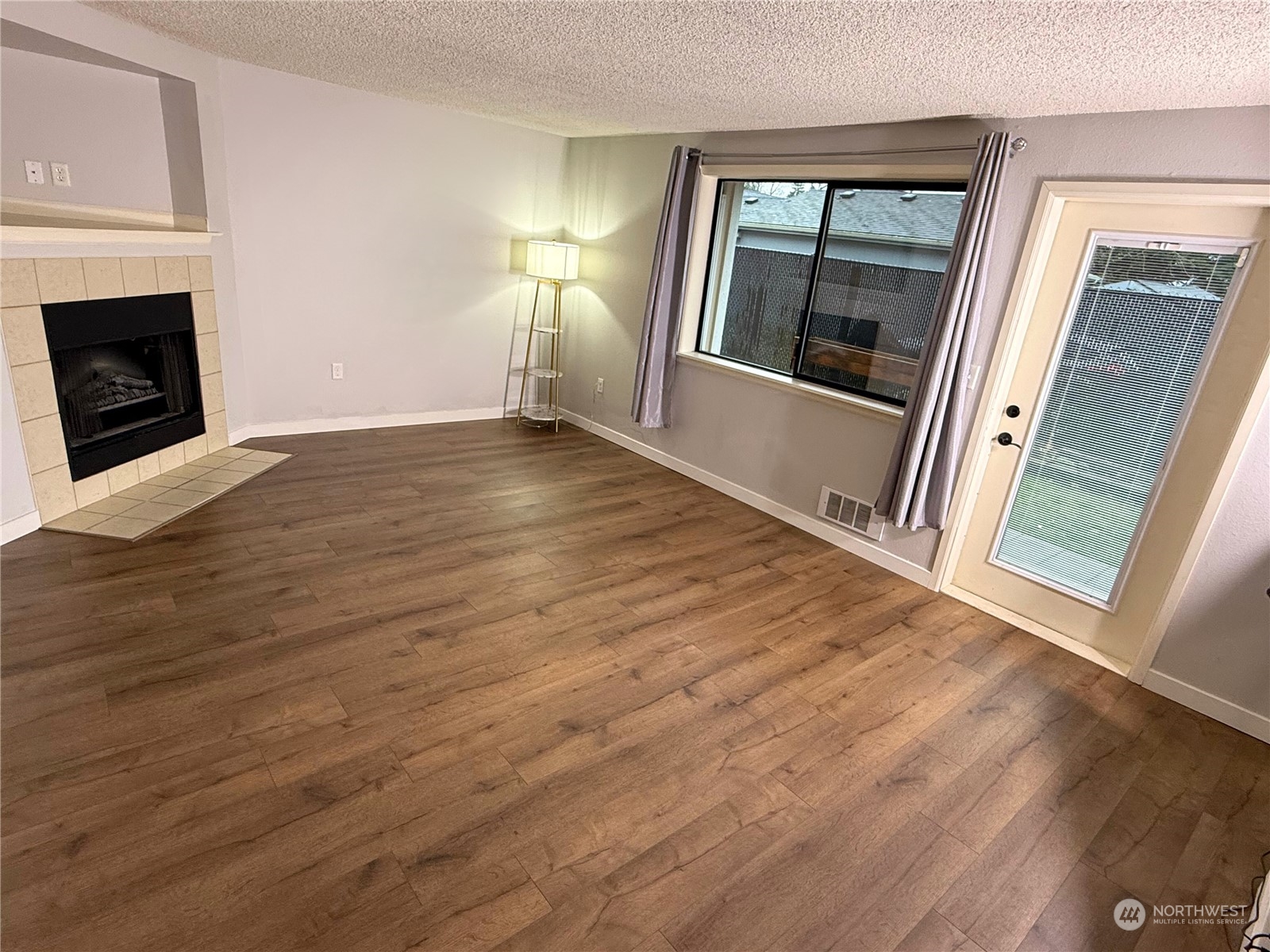 a view of empty room with window and fireplace