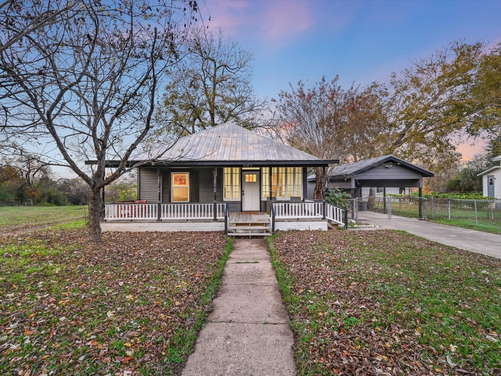 a front view of a house with a yard and trees