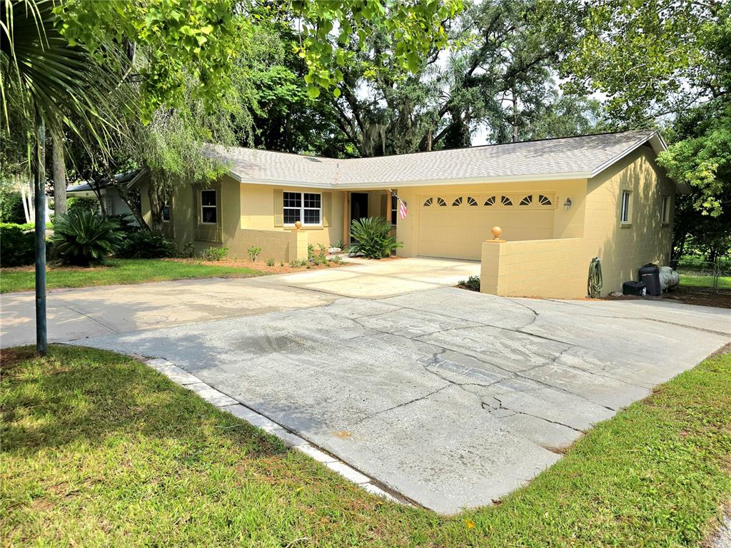 a view of a house with backyard and trees