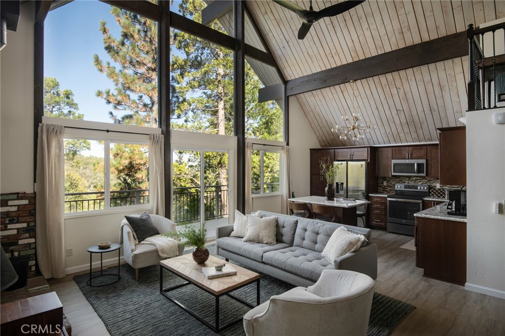 a living room with furniture a flat screen tv and a large window