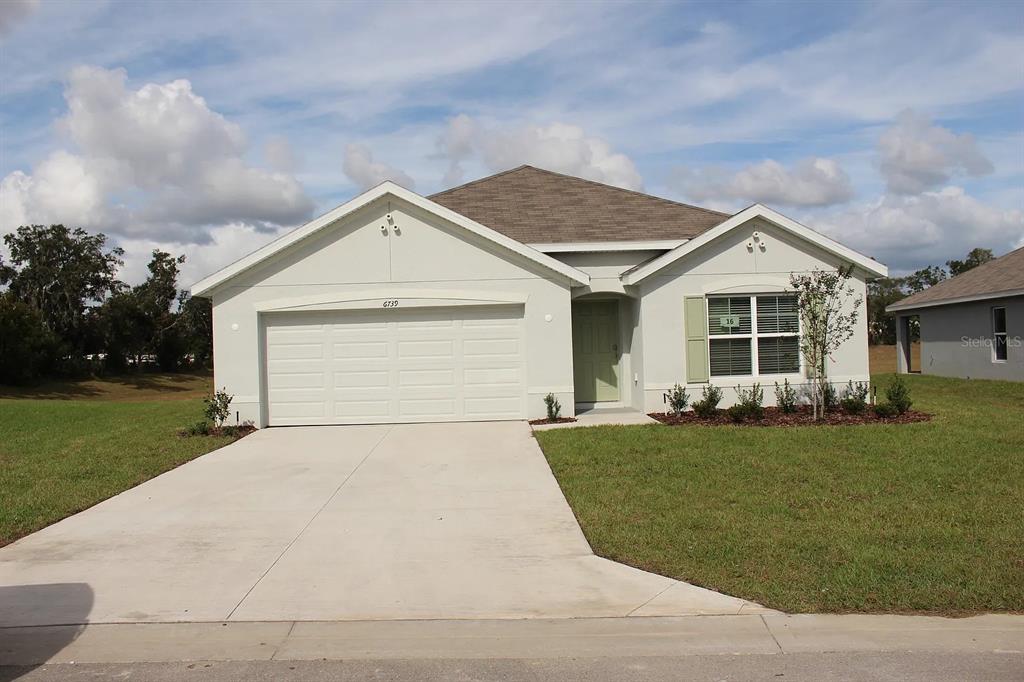 a front view of a house with a garden and yard