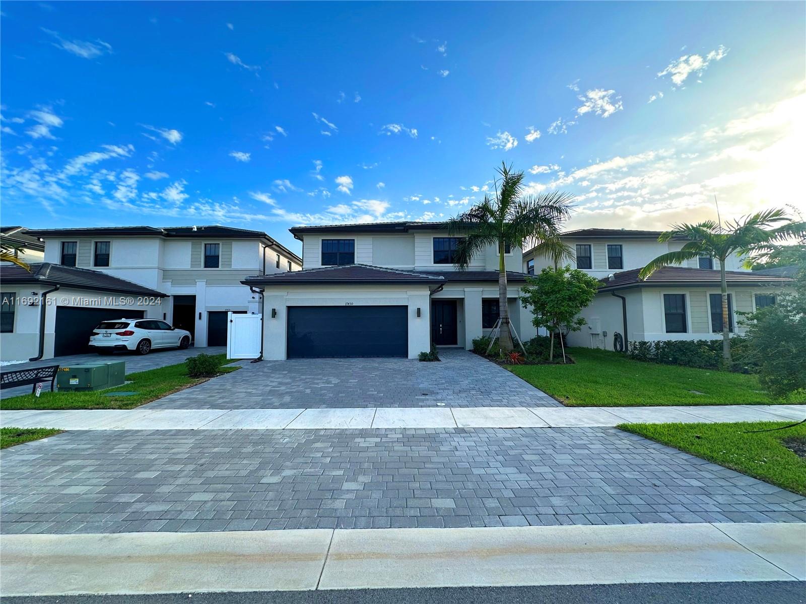 a front view of a house with a yard and a garage