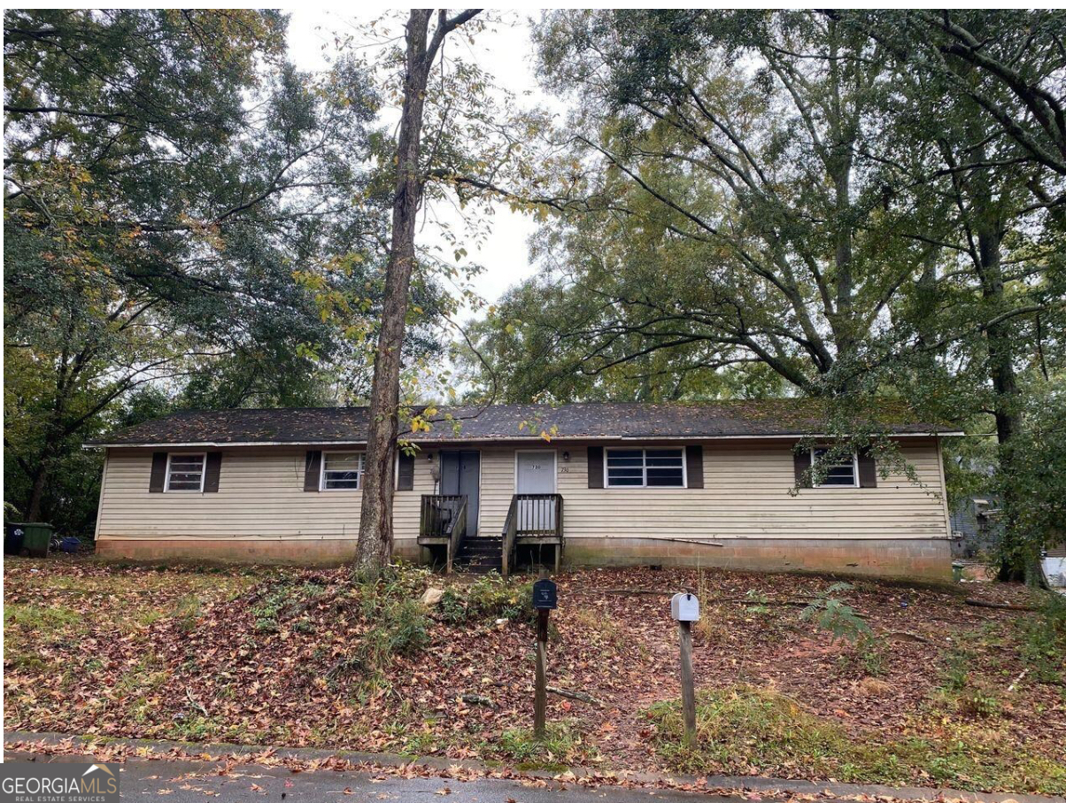 a front view of house with backyard and trees