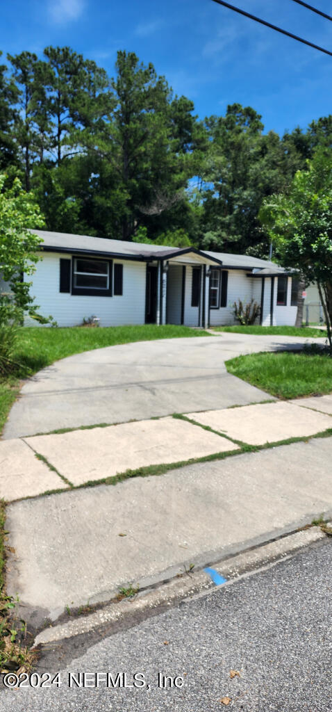 a front view of a house with a yard and trees