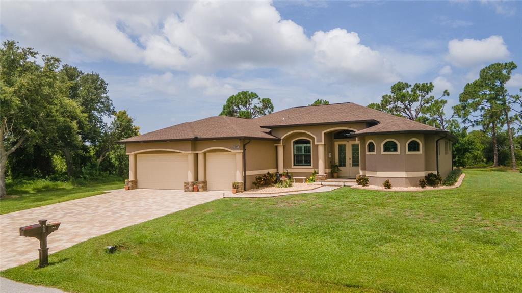 a front view of a house with a garden and yard