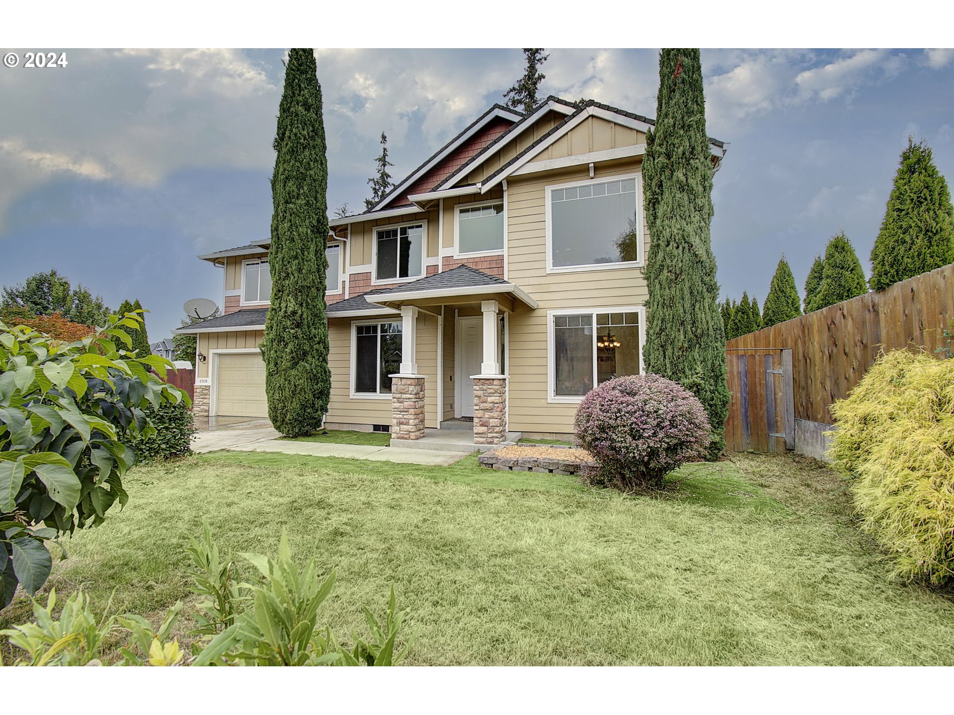 a front view of a house with a garden and yard