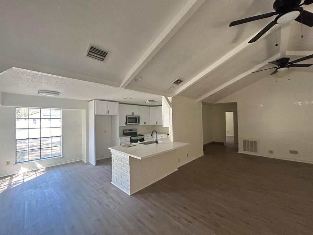 a view of a kitchen with a sink dishwasher and fireplace