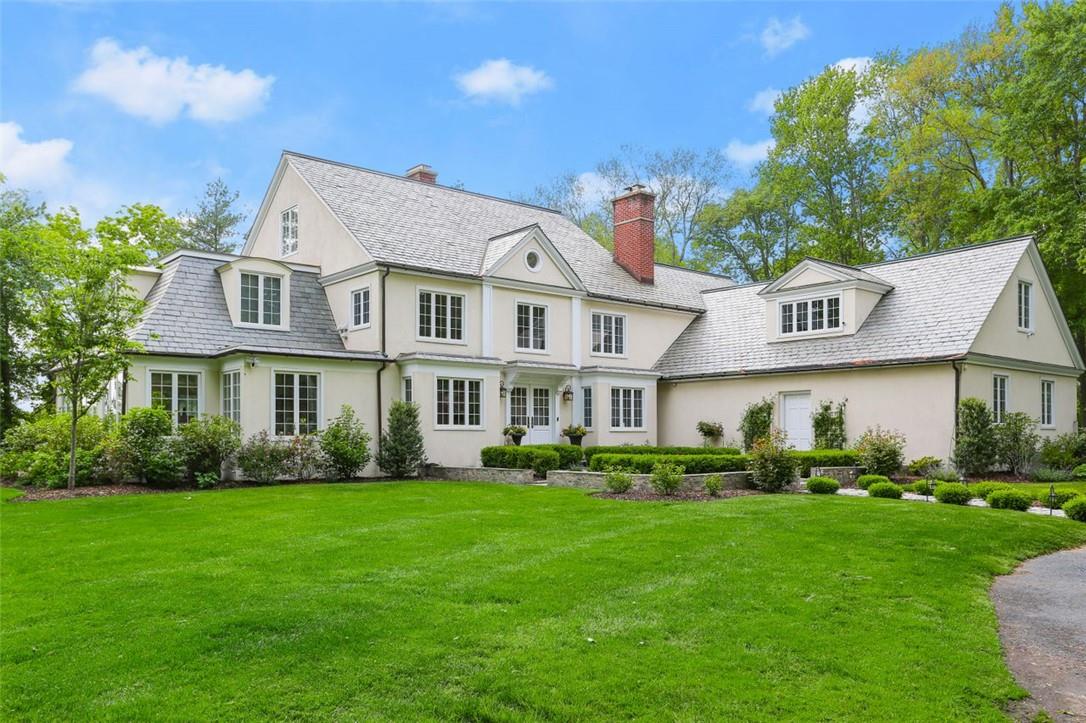 a front view of a house with a garden and plants