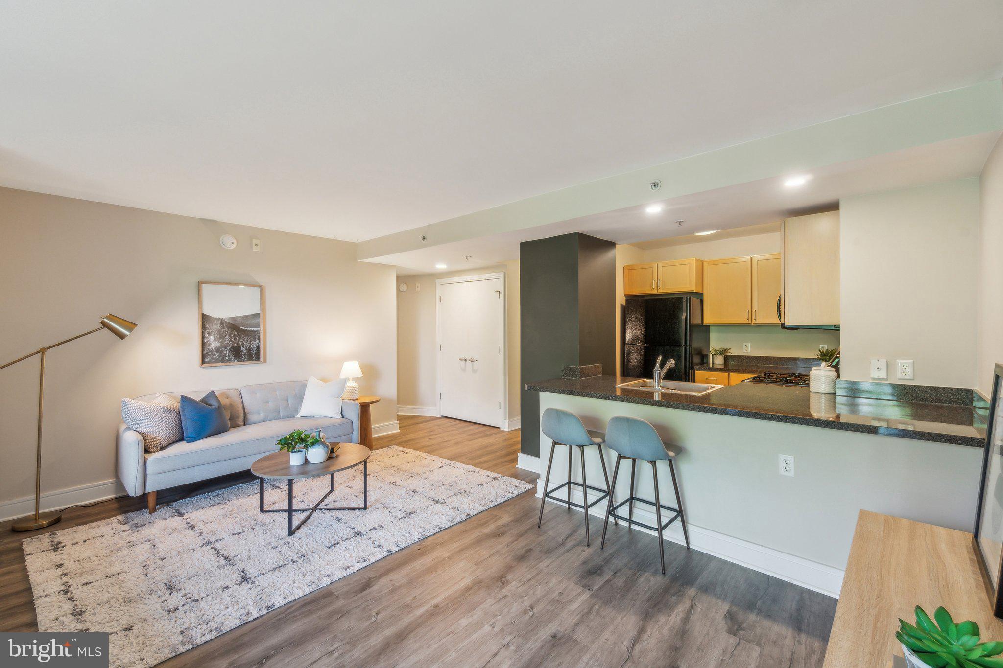 a living room with furniture and kitchen view