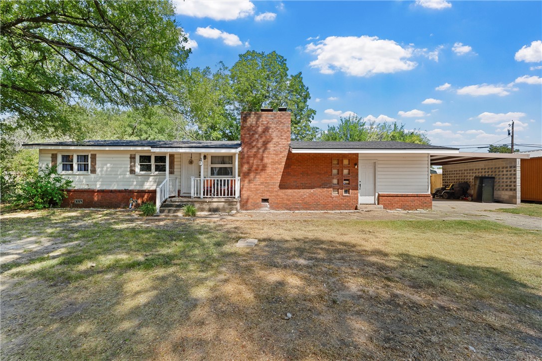 a view of a house with backyard and a tree