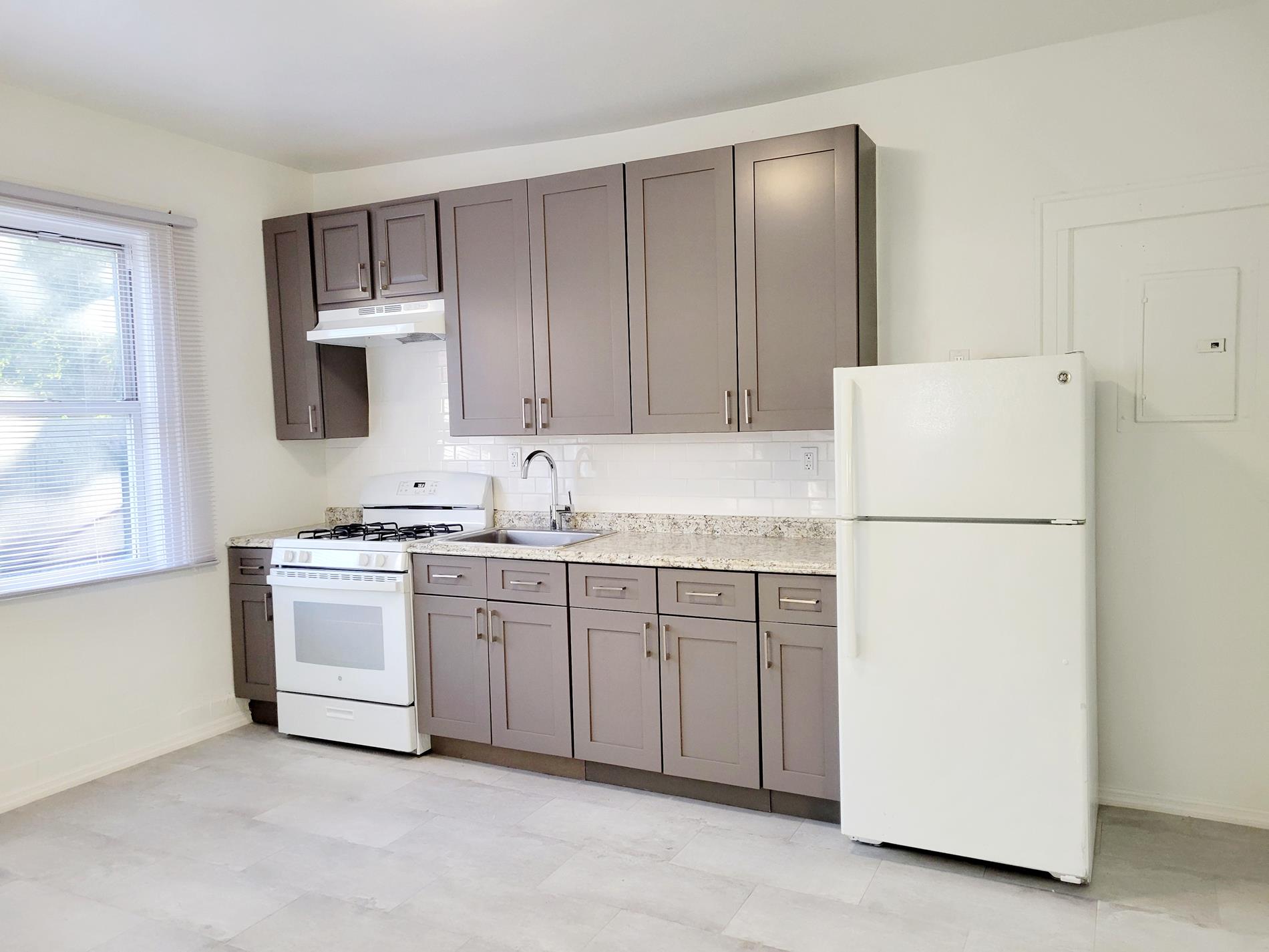 a kitchen with appliances a sink and lots of white cabinets