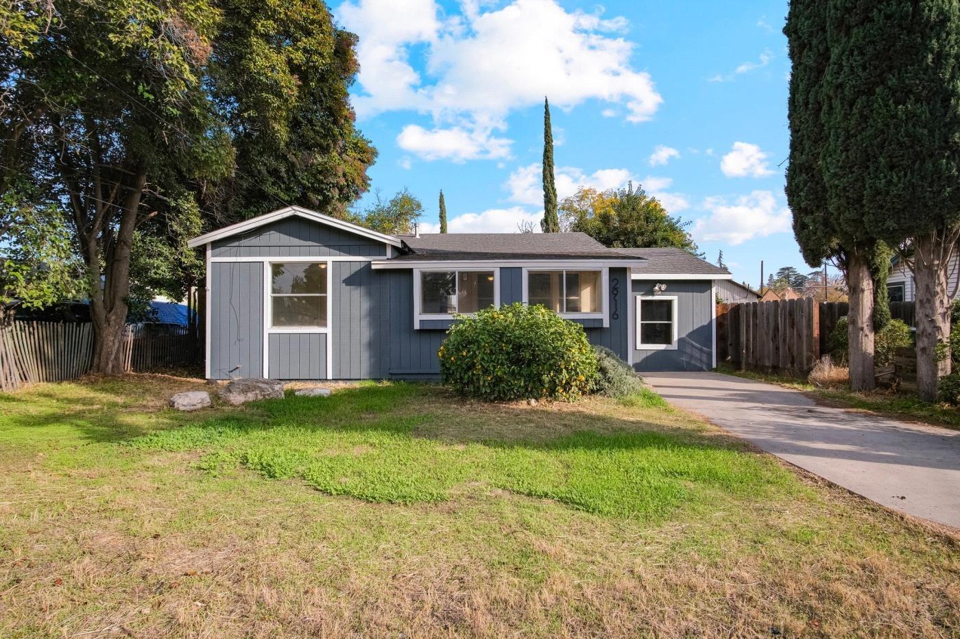 a front view of a house with a garden and yard