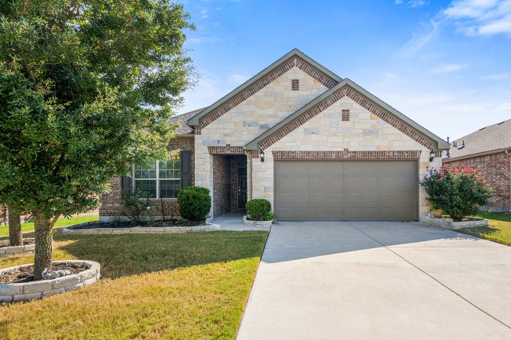 a front view of a house with a yard and garage