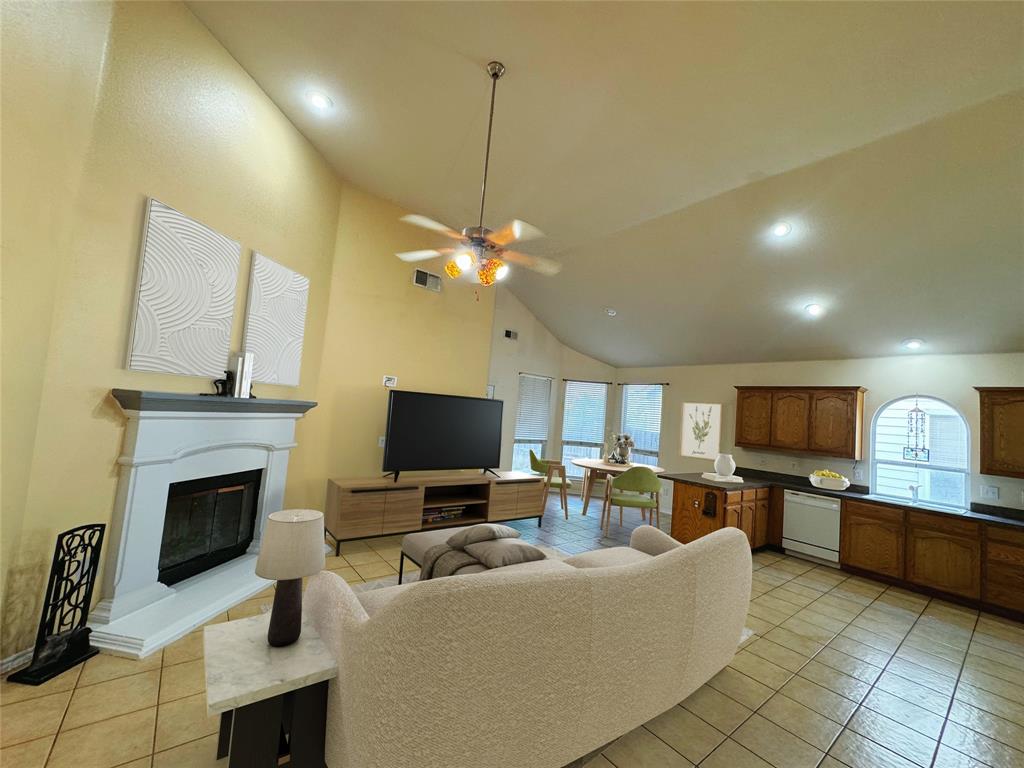 a living room with furniture a fireplace and a flat screen tv