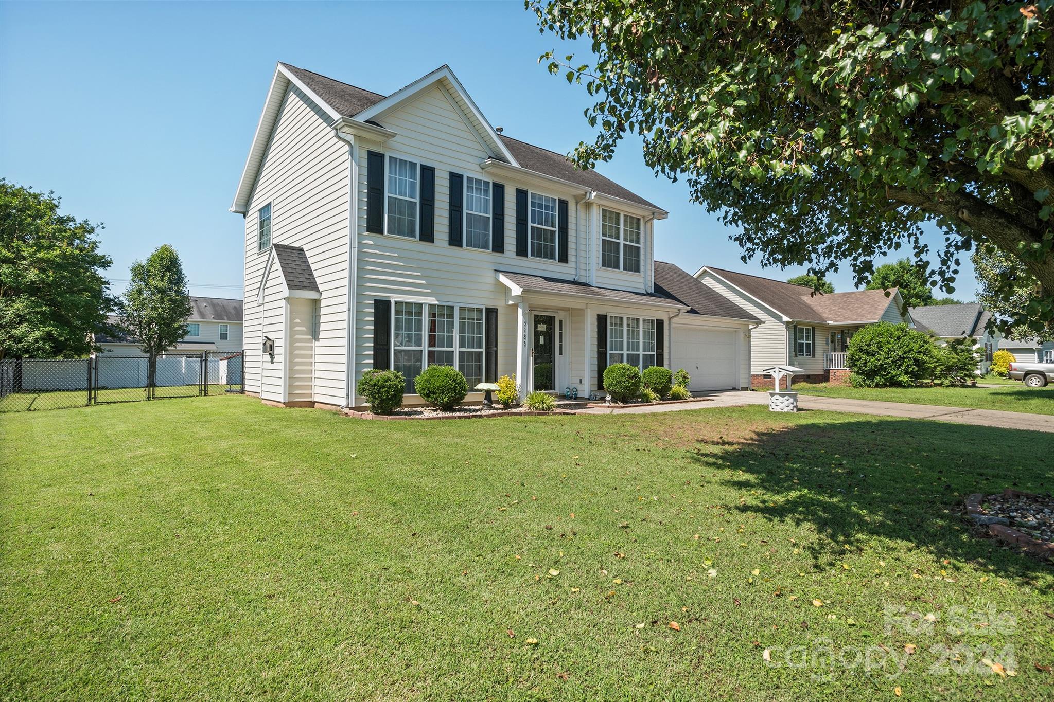 a front view of a house with yard and green space