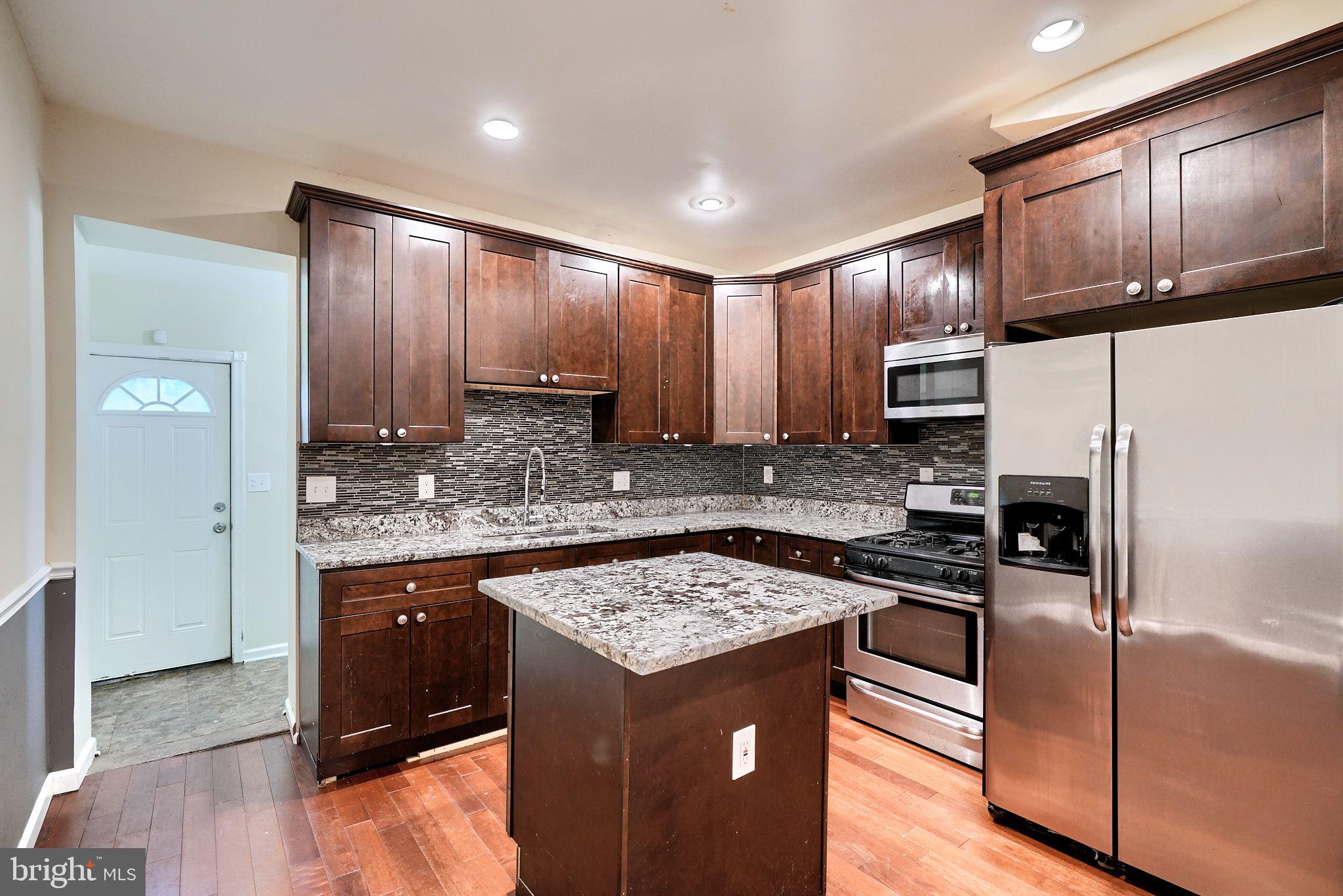 a kitchen with a refrigerator sink and cabinets