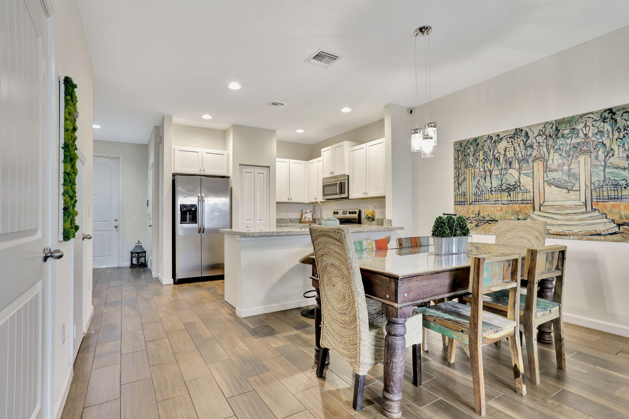 a kitchen with stainless steel appliances kitchen island granite countertop a refrigerator and cabinets