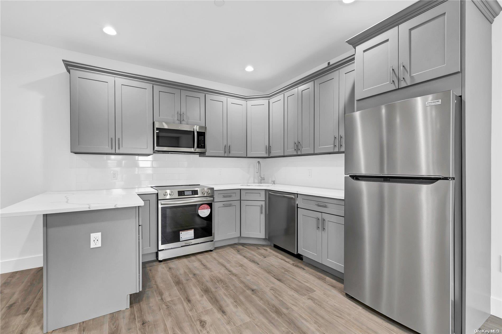 a kitchen with granite countertop a refrigerator stove and sink